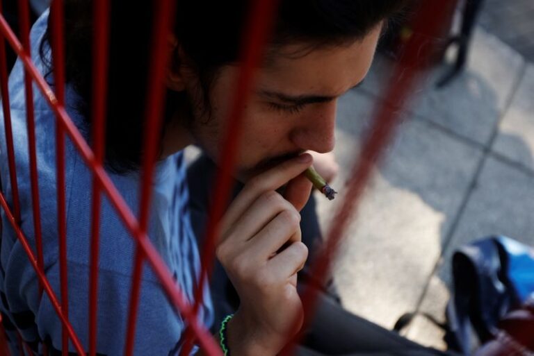 Un hombre fuma marihuana fuera del edificio del Senado mexicano en el jardín de protesta de cannabis del Movimiento Mexicano Cannabico en Ciudad de México