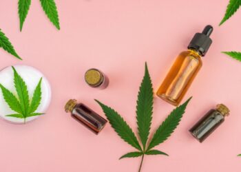 Various bottles with Full spectrum Cannabidiol CBD oils, gel lotion and Cannabis leaf on pastel pink background (Various bottles with Full spectrum Cannabidiol CBD oils, gel lotion and Cannabis leaf on pastel pink background, ASCII, 112 components, 11