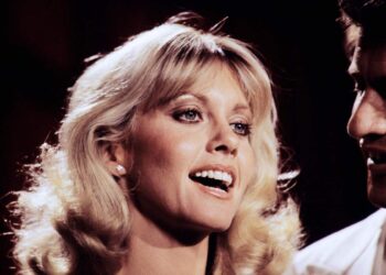 (FILES) In this file photo taken on November 25, 1978 French singer Joe Dassin (R) and Australian actress and singer Olivia Newton-John record a TV show at the Studio des Buttes Chaumont in Paris. - Australian singer Olivia Newton-John, who gained worldwide fame as high-school sweetheart Sandy in the hit musical movie "Grease," died on August 8, 2022, her family said. She was 73. The entertainer, whose career spanned more than five decades, devoted much of her time and celebrity to charities after being diagnosed with breast cancer in 1992. (Photo by GEORGES BENDRIHEM / AFP)